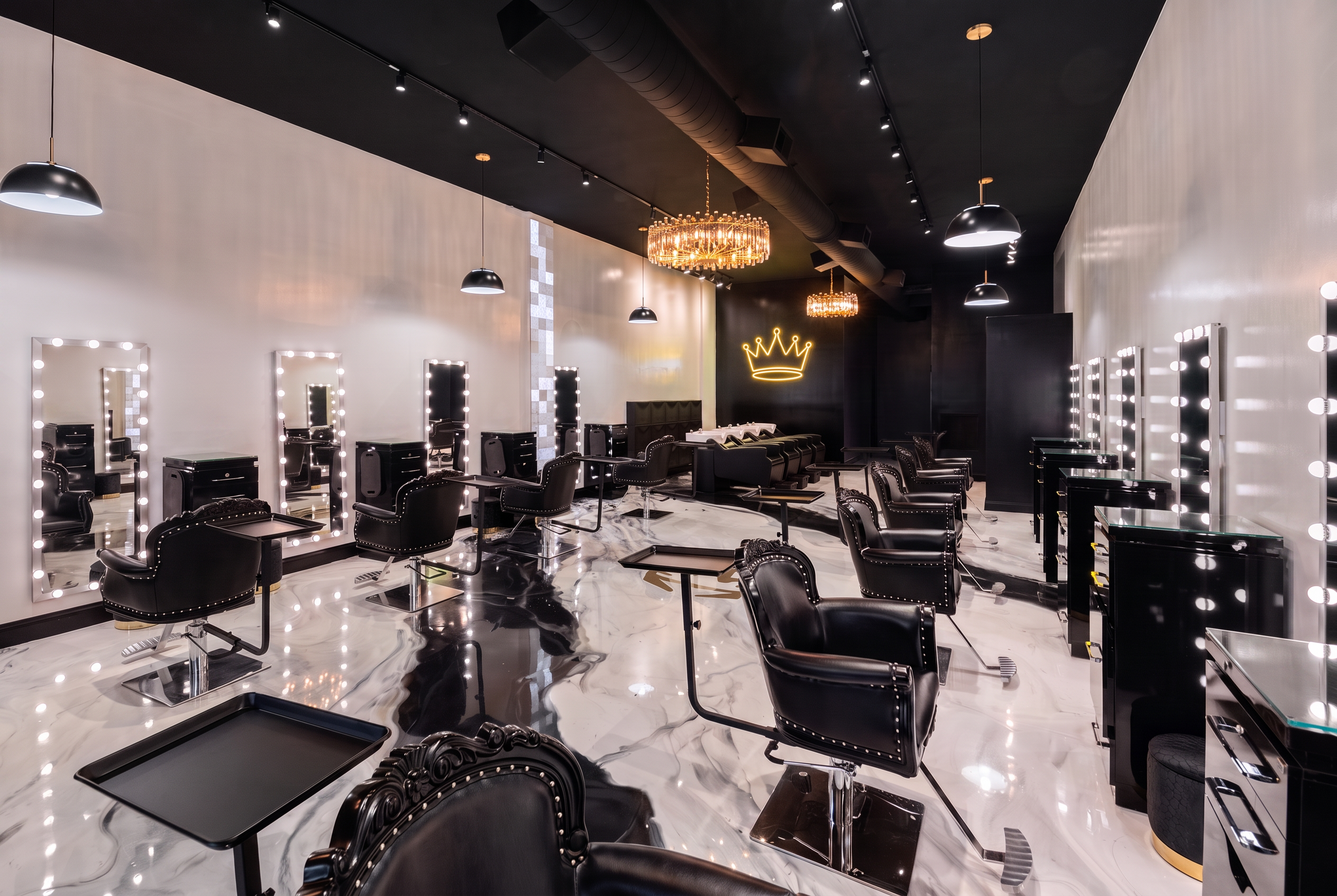The interior of The House of Hair by JMEDiii, styled in black with warm gold light.
