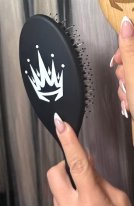 Black The House of Hair signature brush with the white crown mark.